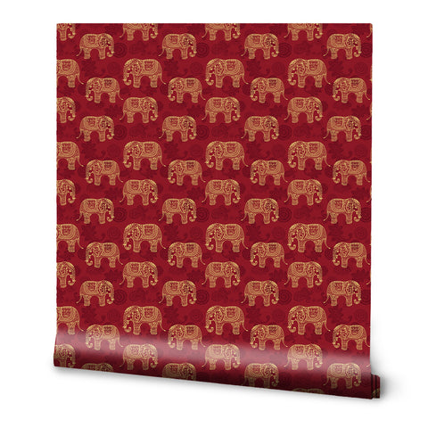 Red wallpaper with repeating golden elephant motifs in traditional ornamental style