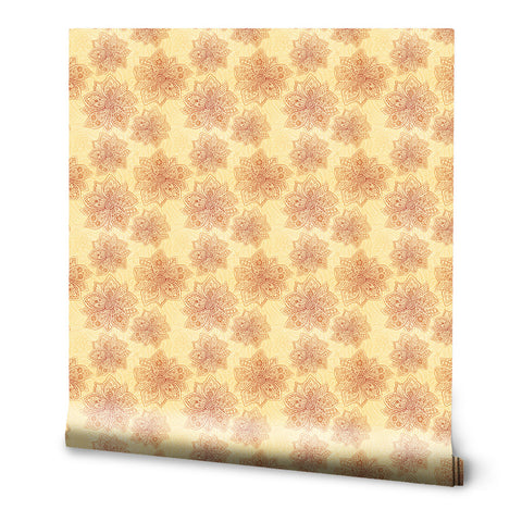 Wallpaper roll with repeating floral mandala pattern in warm orange and beige tones on a light yellow background