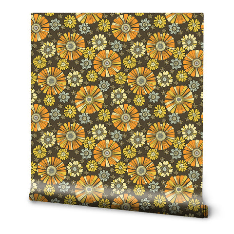 A roll of wallpaper with a 60's floral pattern featuring earthy tones and yellow daisies on a brown background.