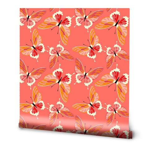 A roll of removable wallpaper with a pattern of coral and peach butterflies on a coral background.