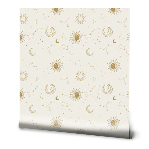 A roll of Creamy Golden Sky removable wallpaper with a celestial pattern featuring moons and stars.