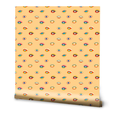 A roll of wallpaper with a pattern of various colorful eyes on a yellow background.