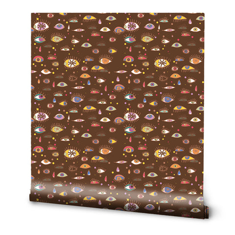 A roll of removable wallpaper with a pattern of various eyes in different colors on a brown background.