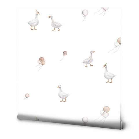 A roll of wallpaper with a design featuring white geese and balloons in a grey background.
