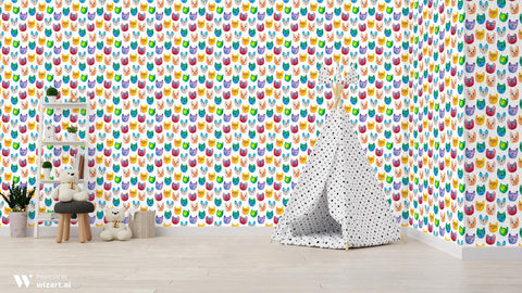 Playroom with walls covered in colorful watercolor cat face wallpaper featuring orange, green, blue, purple, and red cats on a white background, decorated with a toy teepee, shelves, and stuffed animals.