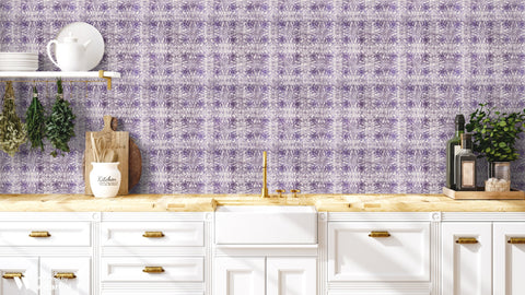 Kitchen with abstract purple floral wallpaper, white cabinets, wooden countertop, and gold faucet