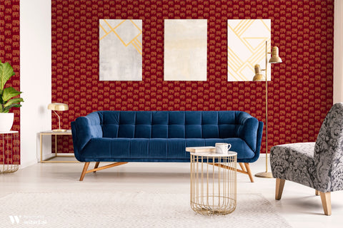 Living room with red wallpaper featuring golden elephant patterns, paired with a blue velvet sofa and modern decor