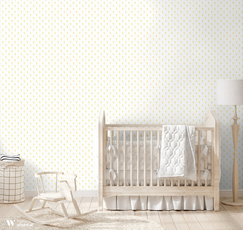 Yellow crescent moon and star patterned wallpaper displayed in a cozy nursery with neutral wooden furniture and soft white accents.