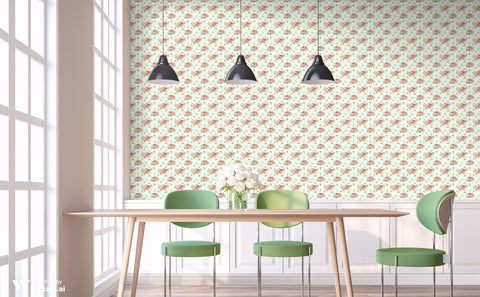 Wallpaper with coral and blush watercolor flowers on a light mint background shown in a bright dining space with green chairs and pendant lights.