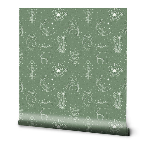 A roll of sage green removable wallpaper with a pattern of eyes, plants, and abstract designs.