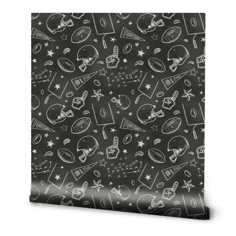 A roll of removable wallpaper with a sports-themed pattern, featuring doodles of a football, basketball, and other sports-related items on a black background.