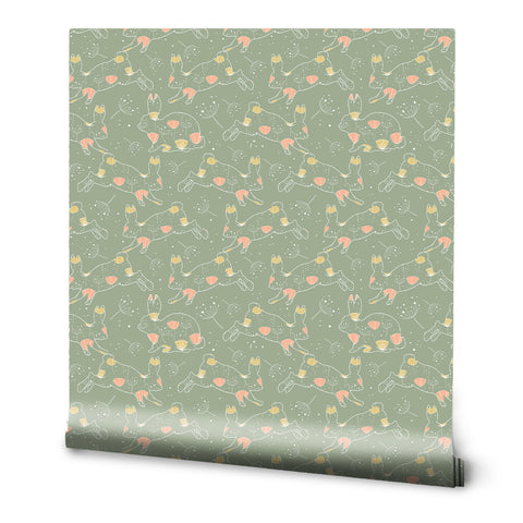 A roll of wallpaper with a green background featuring a pattern of floral and bunny motifs in pink and yellow.