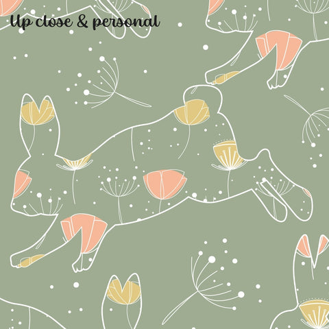 wallpaper with a green background featuring a pattern of floral and bunny motifs in pink and yellow.