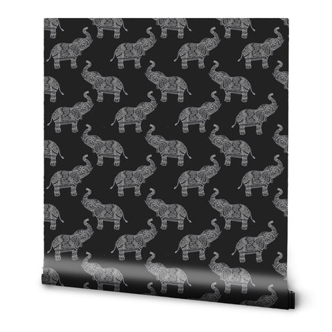 A roll of removable wallpaper with a pattern of black and white elephants inspired by traditional tribal motifs.