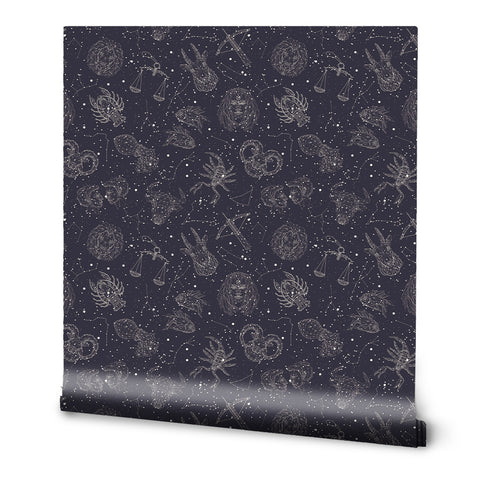 A roll of removable wallpaper with a dark background featuring constellation patterns and zodiac sign motifs.