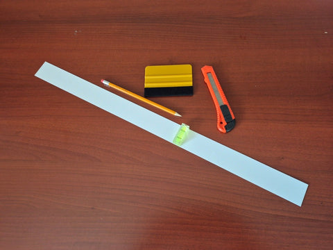 Pencil, ruler, eraser, and sharpener on a wooden surface
