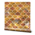 Wallpaper with geometric quatrefoil pattern in warm shades of gold, orange, and brown with stone texture