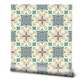 Ornate floral tile pattern wallpaper in beige, teal, and red tones, inspired by Mediterranean design.