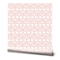 Soft pink ornamental wallpaper with a classic symmetrical design on a white background, ideal for bedrooms or living spaces.