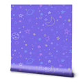 A roll of removable wallpaper with a periwinkle blue background featuring a pattern of stars, planets, and geometric shapes in a variety of colors.