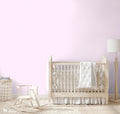 Nursery room with light pink wallpaper featuring a small flamingo pattern, wooden baby crib, rocking horse, floor lamp, and woven basket.