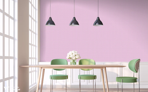 Pink wallpaper with white circular motifs displayed in a dining room with modern green chairs, a wooden table, and black pendant lights.