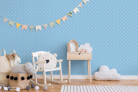 Dusty blue wallpaper with small white paisley and floral motifs displayed in a nursery with wooden furniture, toys, and pastel bunting decor.