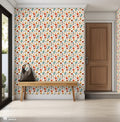 Colorful floral wallpaper with orange, mustard, and teal flowers and brown leaves on a light cream background, shown in a modern entryway with a wooden bench and neutral decor