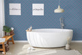 Blue geometric floral wallpaper in a modern bathroom with white bathtub and minimalist decor.