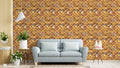 Living room with light gray sofa and plants against wallpaper featuring geometric quatrefoil pattern in gold, orange, and brown stone texture