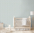 Gray wallpaper with turquoise cartoon birds, hearts, and whimsical line details displayed in a bright nursery with natural wood furniture.