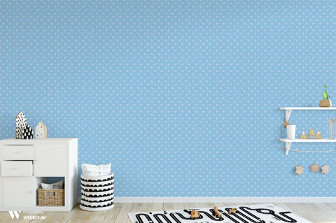 Dusty blue wallpaper with white paisley and floral pattern shown in a modern children’s room with white furniture and wooden accents.