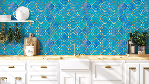 Kitchen wall with blue Moroccan-style quatrefoil wallpaper featuring gold outlines, paired with white cabinets, wooden countertop, and hanging herbs