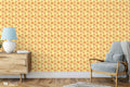 Modern interior with wooden cabinet and blue armchair against yellow wallpaper with orange floral mandala pattern
