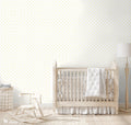Yellow crescent moon and star patterned wallpaper displayed in a cozy nursery with neutral wooden furniture and soft white accents.