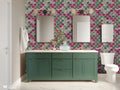 Bathroom with green vanity and double mirrors against wallpaper featuring geometric arabesque pattern in gray, green, and magenta with stone texture