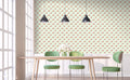 Wallpaper with coral and blush watercolor flowers on a light mint background shown in a bright dining space with green chairs and pendant lights.