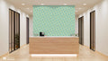 Office reception area with wooden desk and accent wall covered in turquoise and terracotta geometric tile-pattern wallpaper