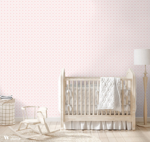 Light pink wallpaper with delicate heart and floral motifs displayed in a nursery with a wooden crib, rocking horse, and neutral decor.