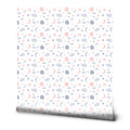 A roll of removable wallpaper with a pattern of fluffy clouds, shining stars, and charming moons in various colors on a white background.