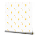 White wallpaper with a simple crescent moon, star, and hanging orb pattern in soft yellow and gold tones.